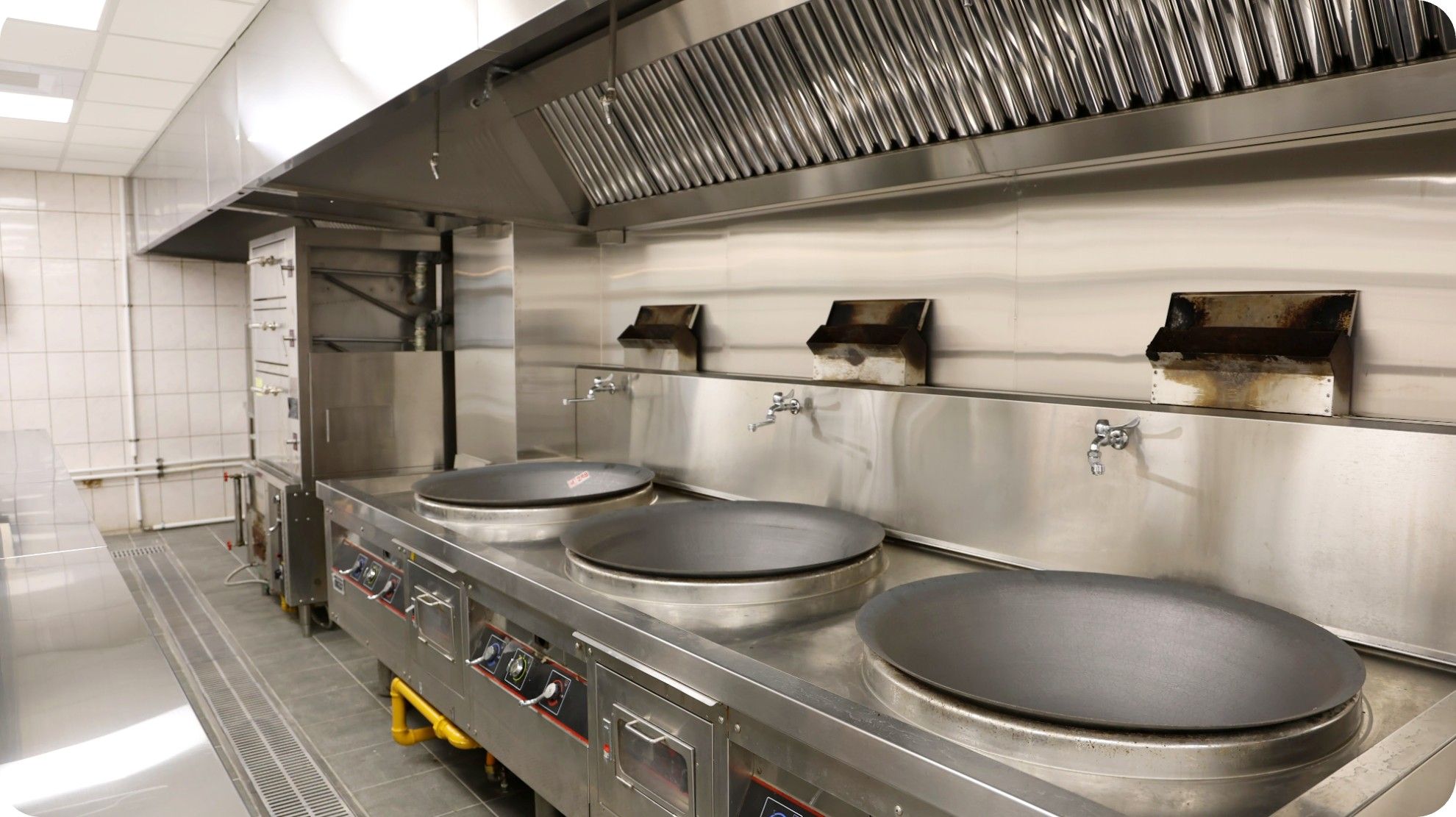 Cooking line and extraction hood, volume catering kitchen